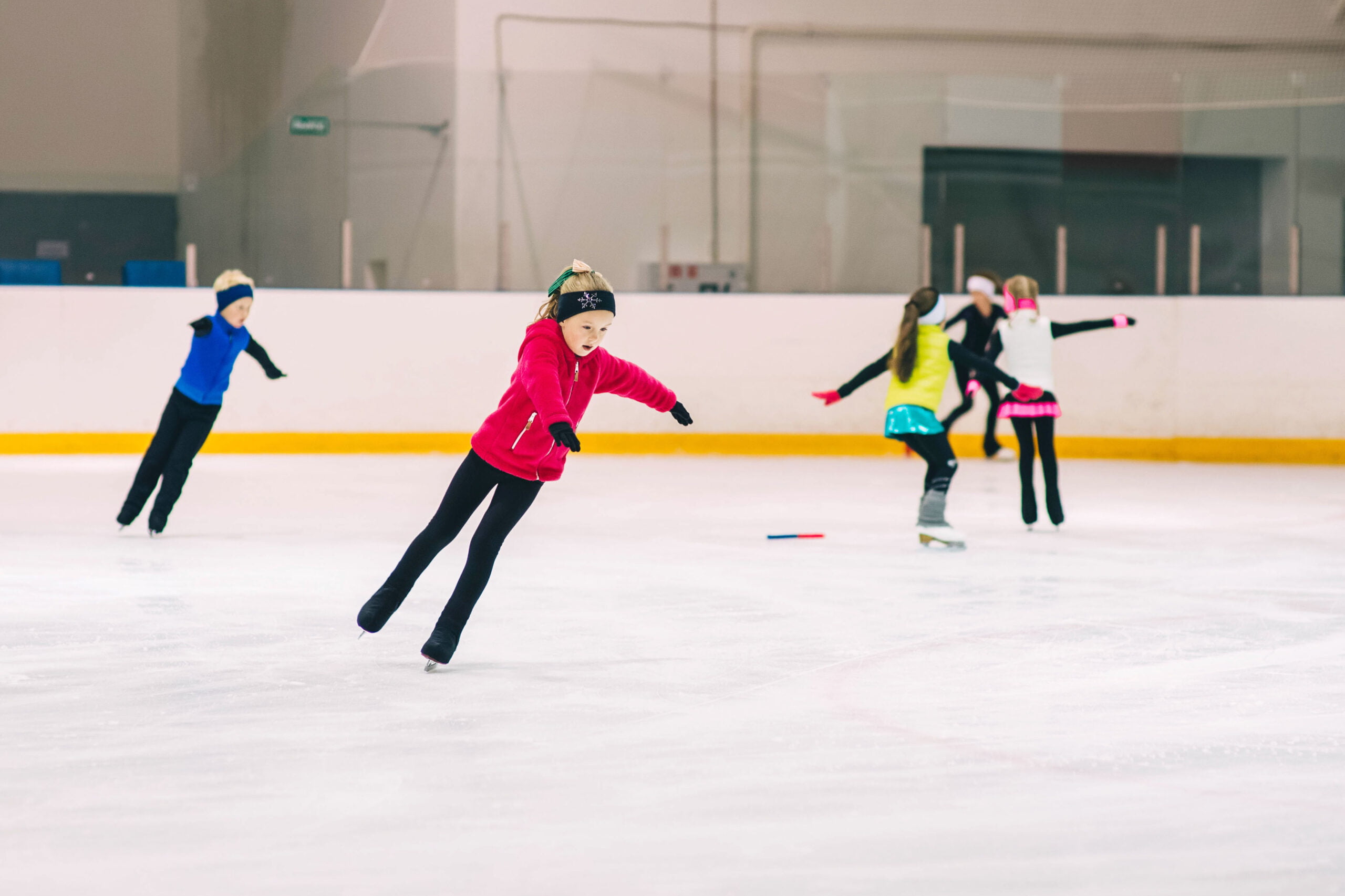 Little girl learning to ice skate. Figure skating school. Young