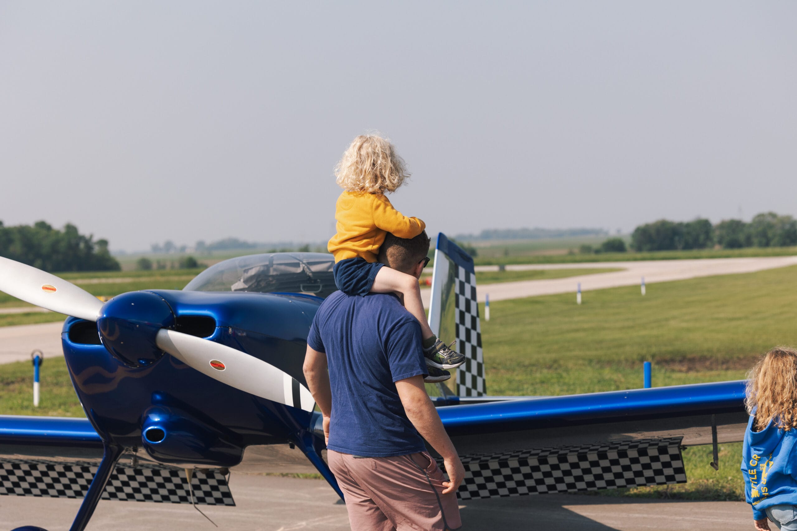 Families exploring airplanes at a fly-in event