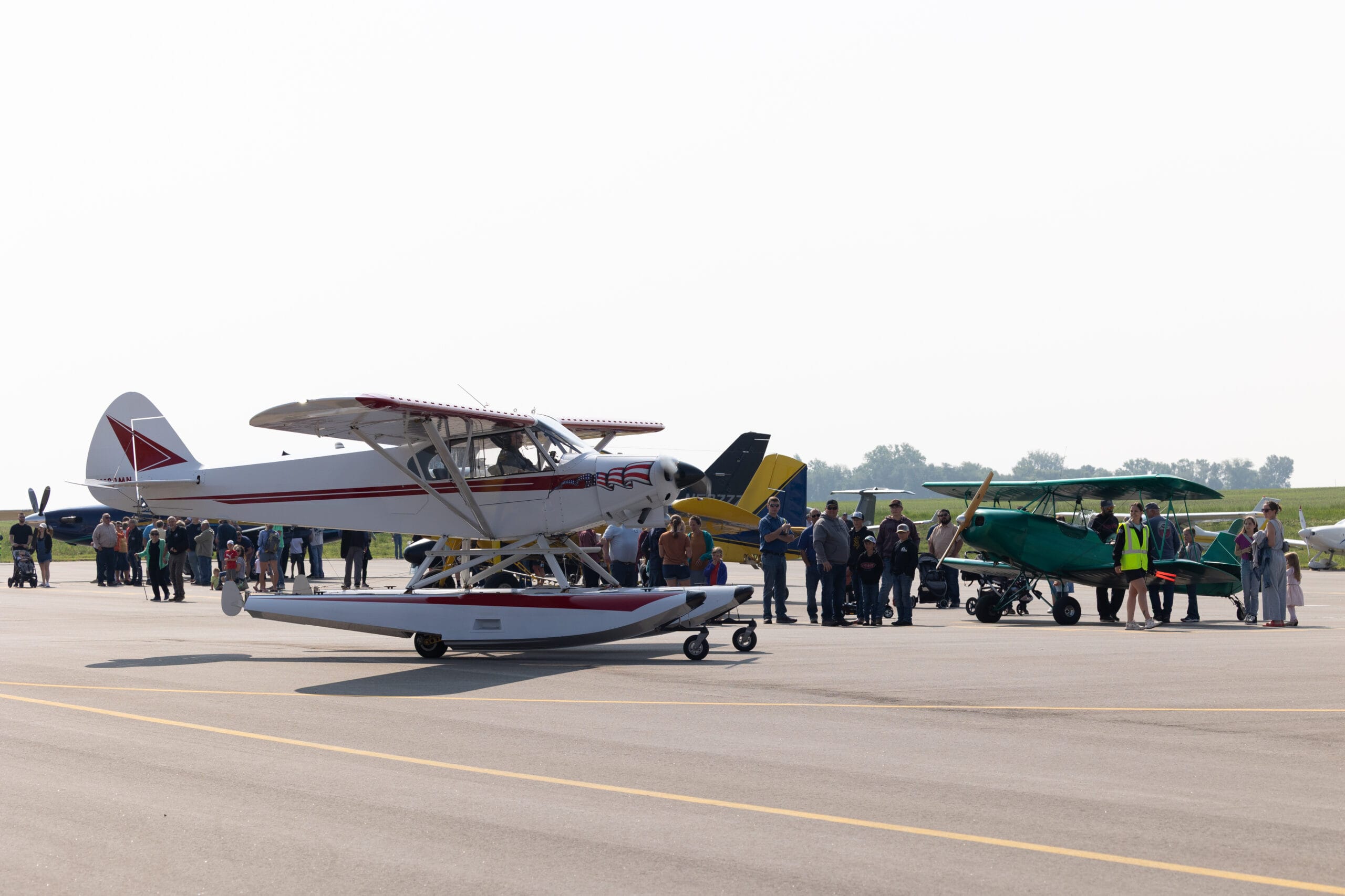 Airplanes parked on the runway during a fly-in event